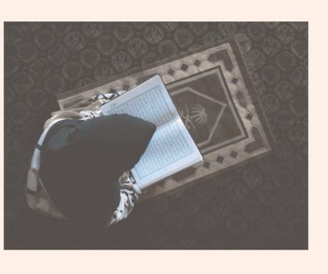 A woman reading the Qur'an on a prayer mat — symbolising spiritual care at the heart of Sherise.